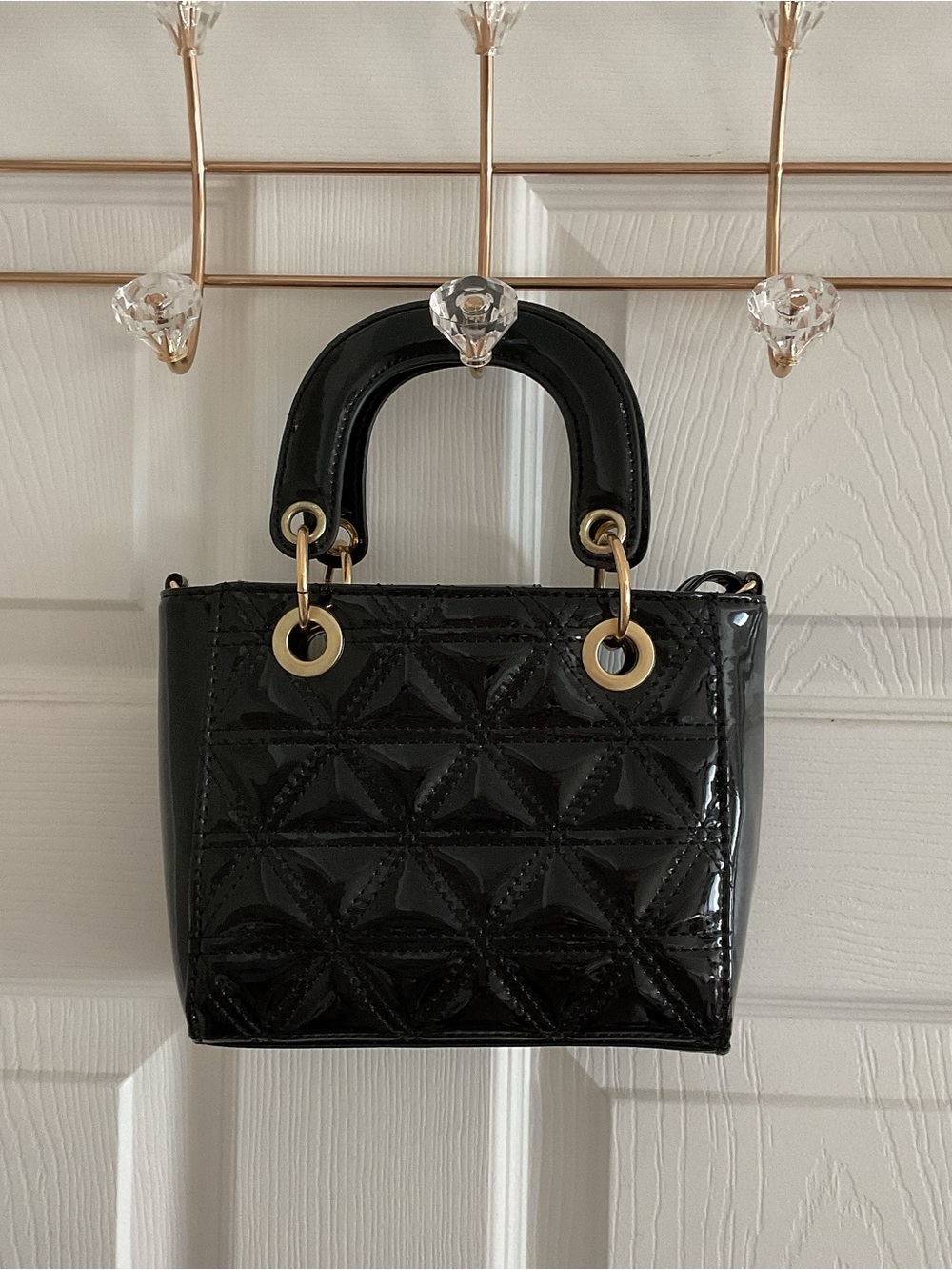Black quilted top handle bag with gold hardware